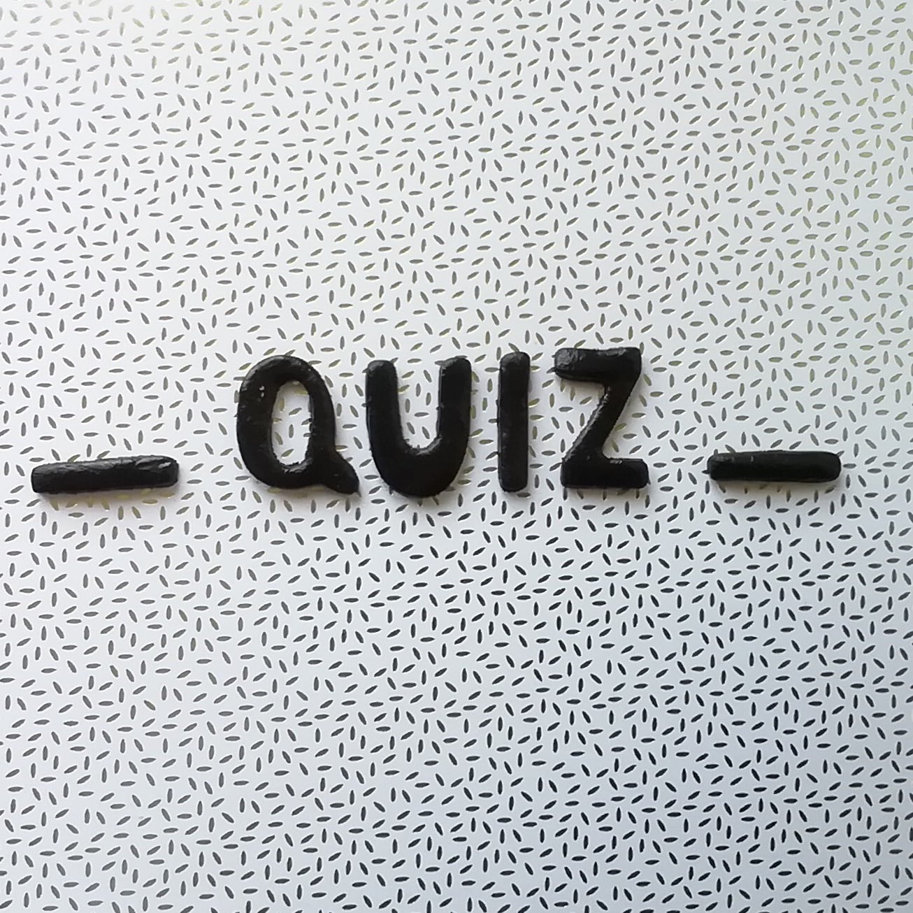 Des lettres réalisées en pâte polymer composent le mot "quiz".