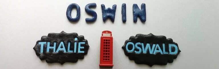 Une cabine téléphonique anglaise est entourée par trois prénoms : Oswin, Thalie et Oswald.